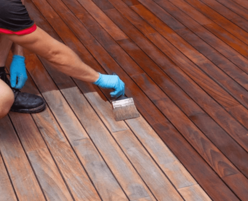 Professional worker staining a deck at Ponderosa Painting.