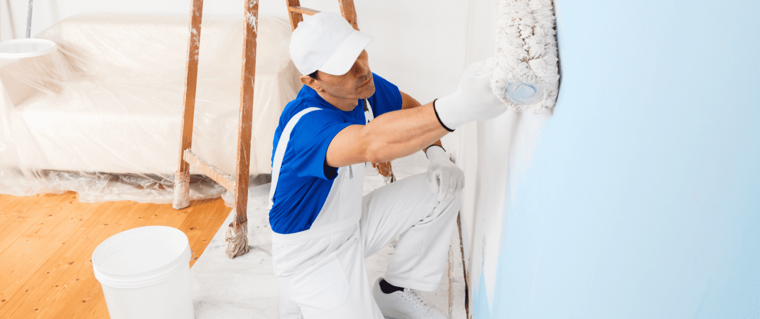 Professional painter applying a fresh coat of blue paint on an interior wall, detailing the quality and expertise offered by Ponderosa Painting services.